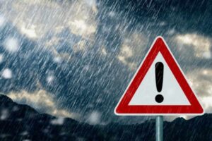 Pioggia battente sul cartello di pericolo