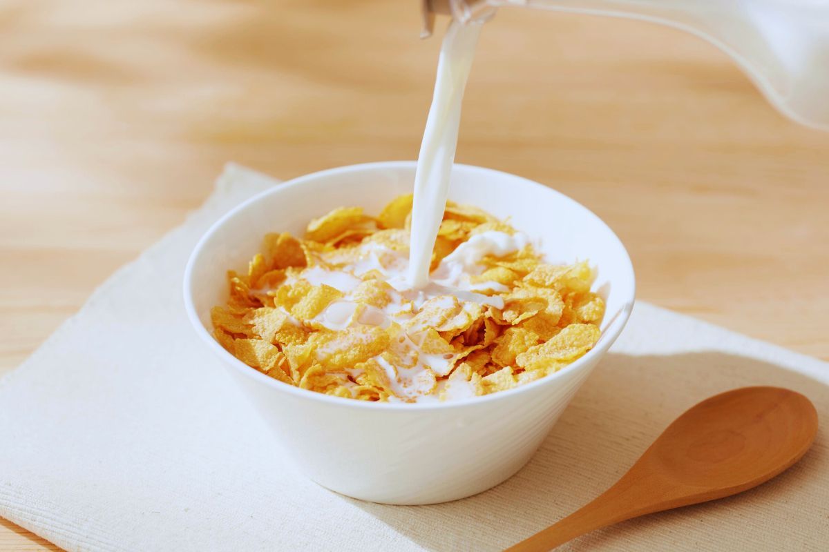 Latte versato in una ciotola piena di cereali