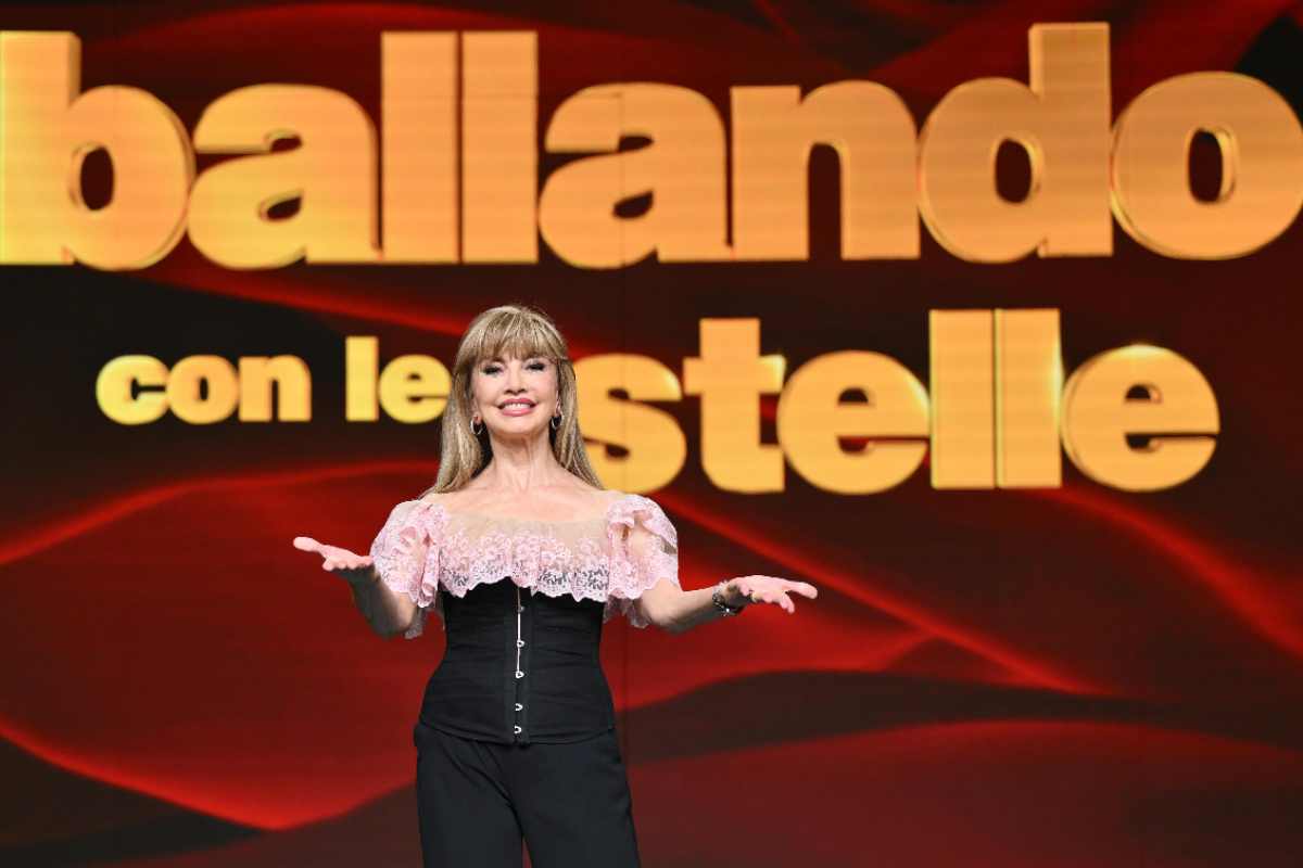 Milly Carlucci in posa davanti al logo di Ballando con le Stelle