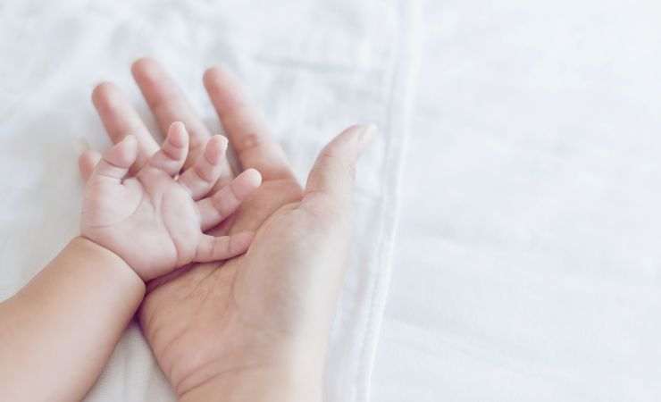 manina di neonato nella mano della mamma
