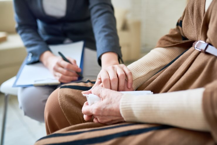 mano che stringe mano ad un'altra persona, blocco appunti e penna 