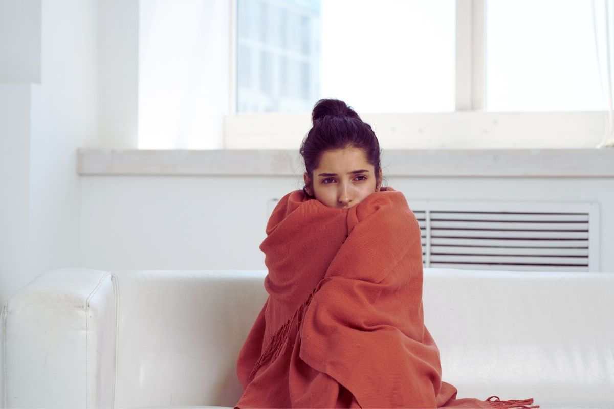 ragazza si copre con una coperta sul divano