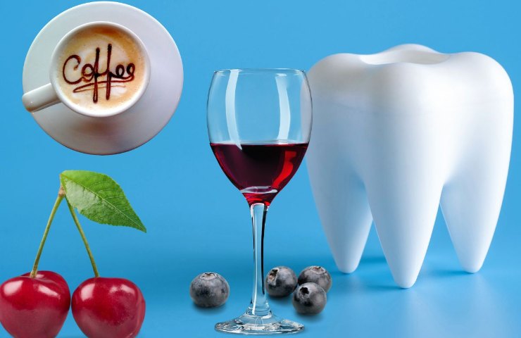  dente con alimenti e bevende che macchiano i denti : caffe , ciliegie, mirtilli, vino rosso 