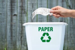 Persona getta lo scontrino nel secchio della carta
