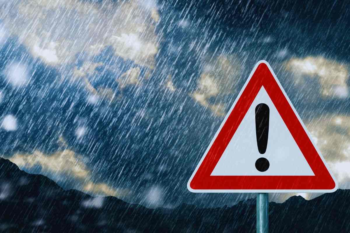Segnale di pericolo bagnato da pioggia battente