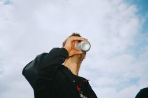 Uomo che beve birra in lattina
