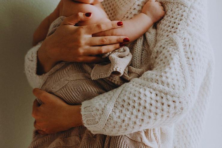 Mamma che tiene in braccio il figlio neonato