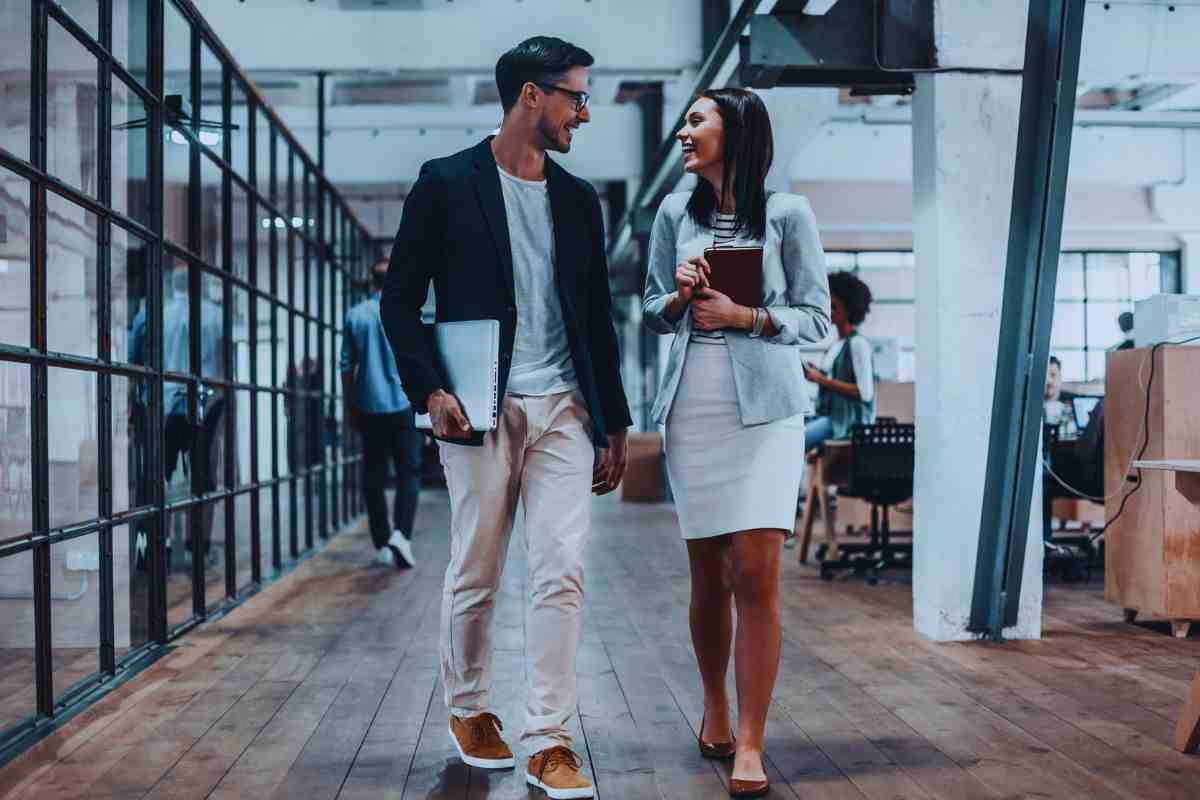 Uomo e donna in abiti da lavoro che parlano e ridono