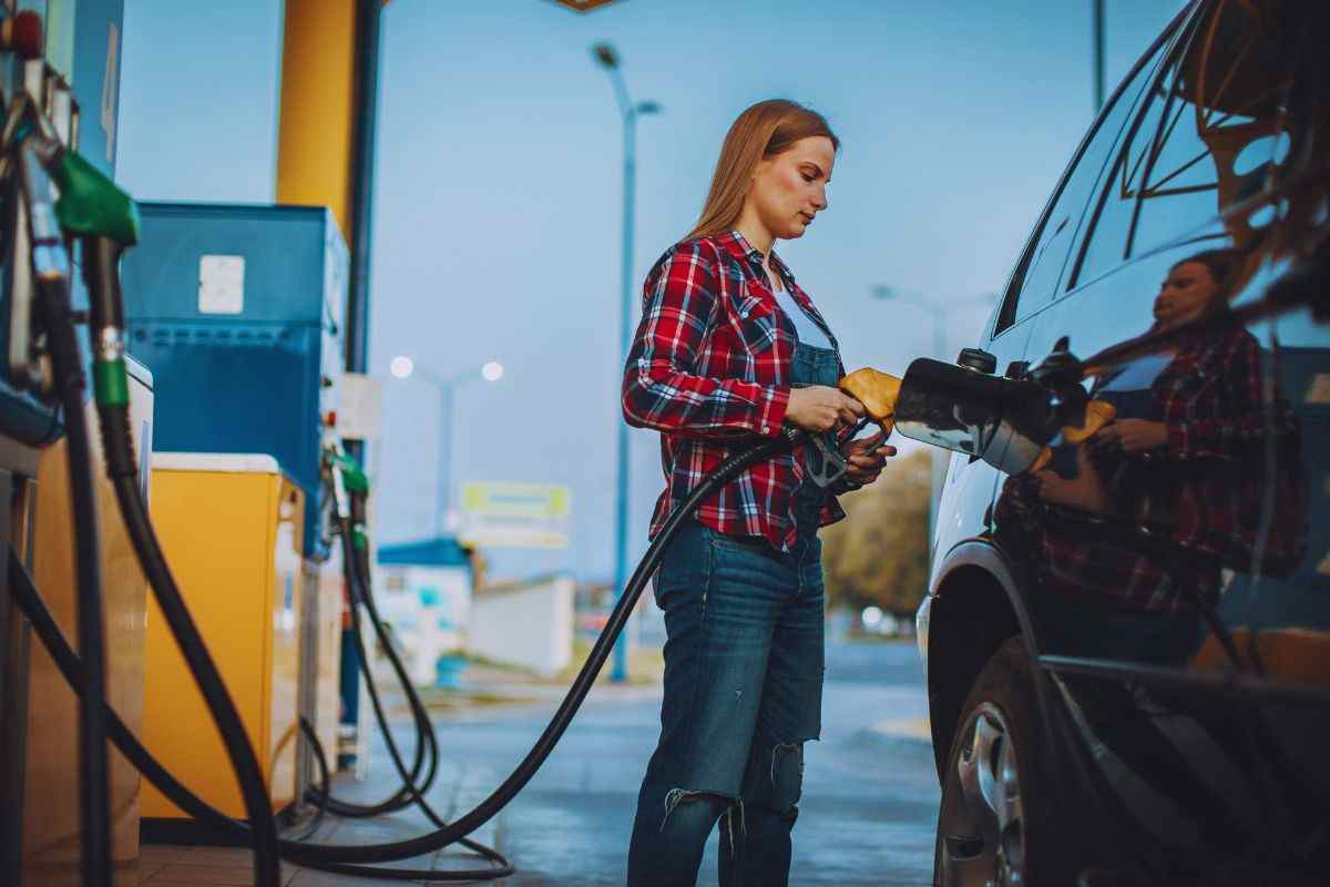 Donna che effettua rifornimento all'auto