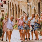 Turiste che ascoltano la guida mentre visitano il borgo medievale di Volterra