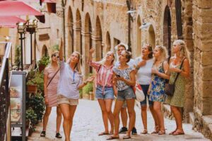 Turiste che ascoltano la guida mentre visitano il borgo medievale di Volterra