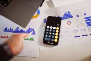 Grafici e calcolatrice poggiati su scrivania