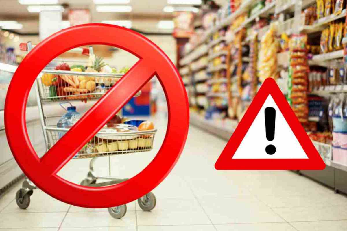 Carrello sbarrato in corsia supermercato e segnale di pericolo accanto