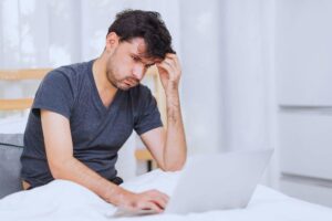 Uomo che sbuffa mentre guarda il PC