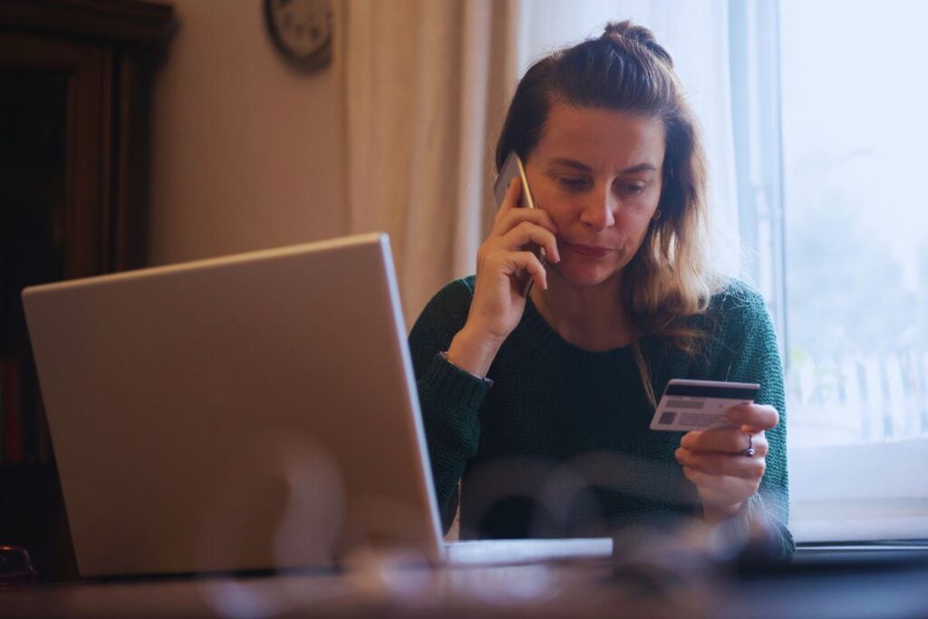 Donna al telefono con carta di credito in mano