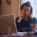 Donna al telefono con carta di credito in mano