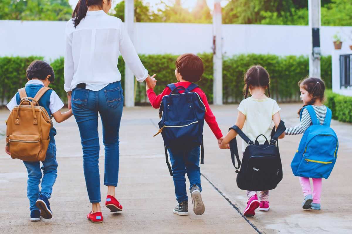 Donna che accompagna bambini all'asilo