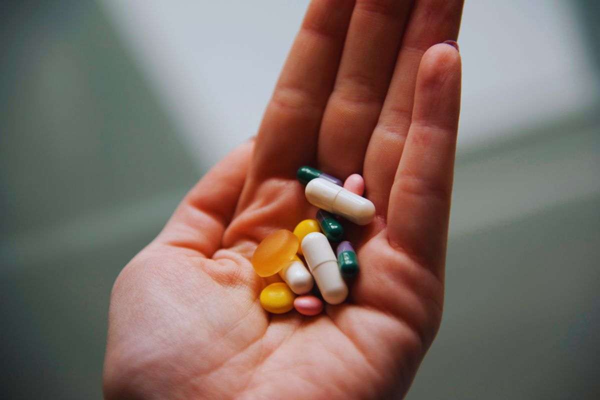 Persona che tiene in mano diversi medicinali