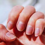 Donna che si guarda le unghia di una mano