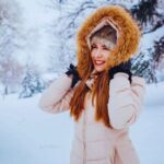 Ragazza sorridente in mezzo ad un bosco innevato