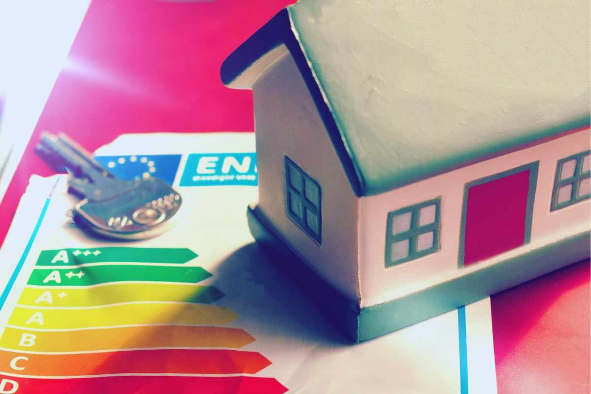 modellino casa e chiave poggiati su tabella valori consumo energetico