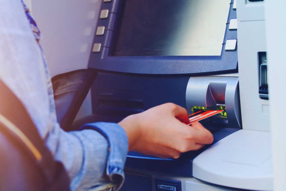 Donna che inserisce carta nell'ATM