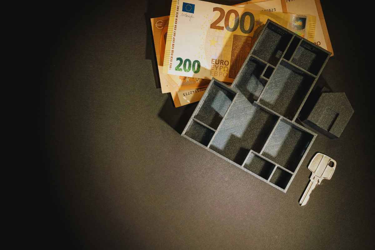 banconote, pianta casa in 3D e chiave poggiate su tavolo